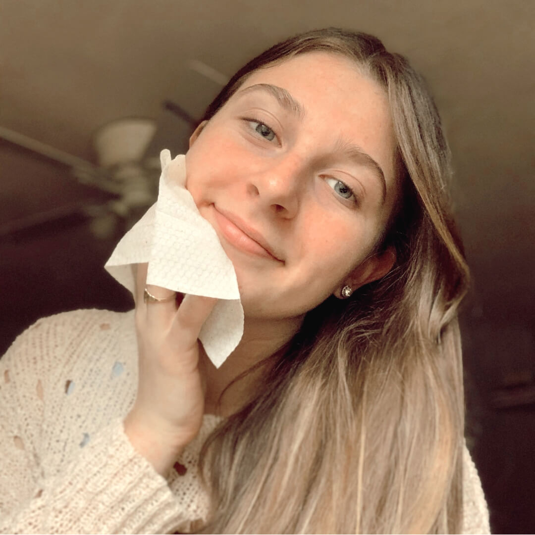 Smiling woman wiping face with Busy Beauty wipe